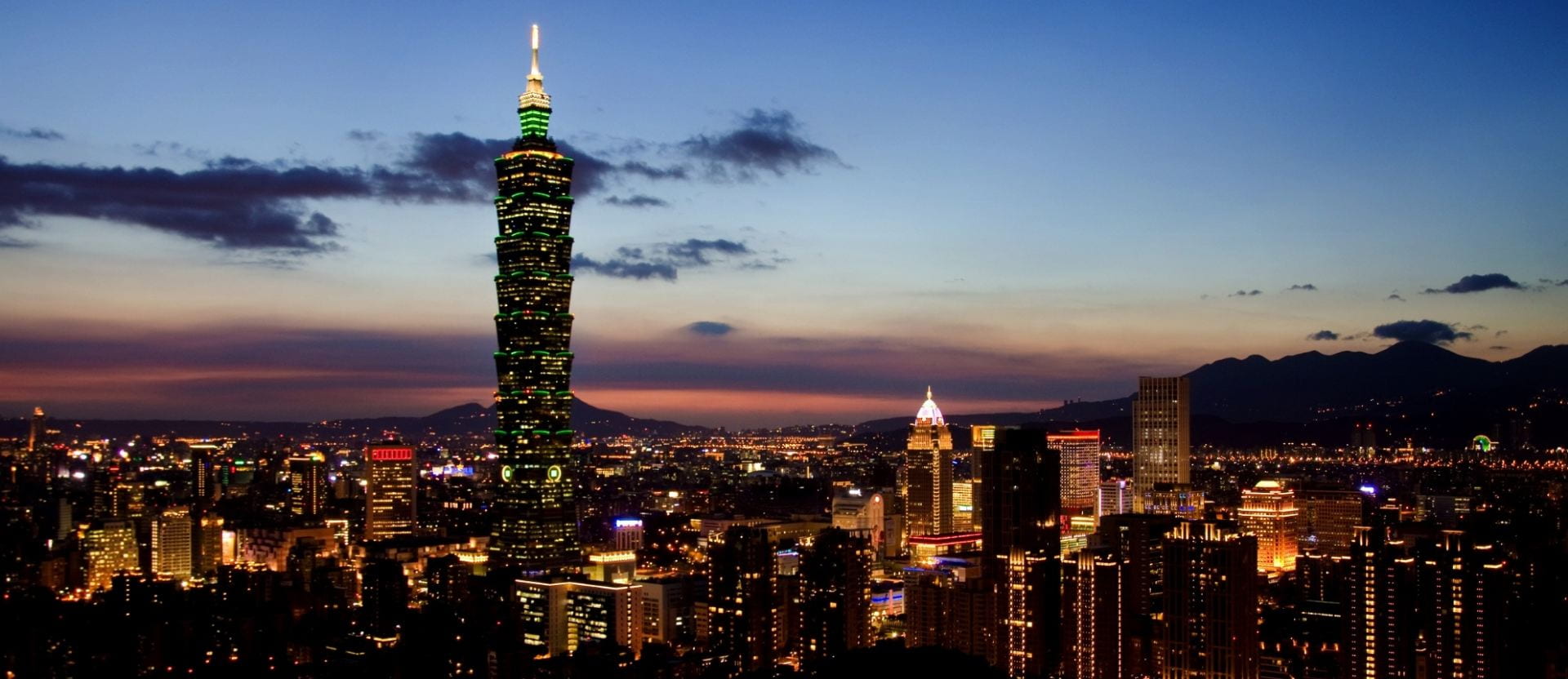 skyline of Taipei at dusk with buildings lit up